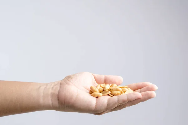 Hand hält Haufen von Salz gerösteten Erdnüssen — Stockfoto