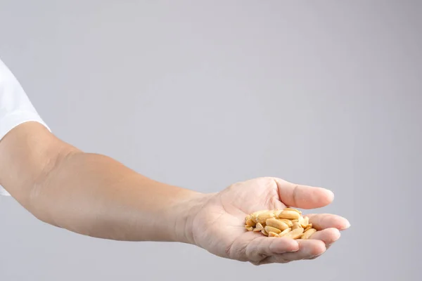 Mão segurando amontoado de sal torrado amendoim — Fotografia de Stock