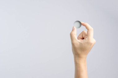 Klasik bira veya soda şişe kapağı tutan el