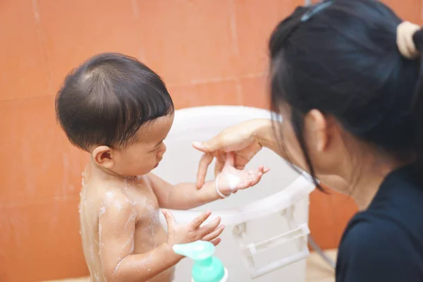 アジアの母が一人でシャワーを浴びる彼女の赤ちゃんを教える — ストック写真