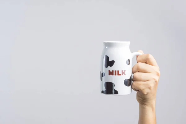 Mano che tiene una tazza con motivo di latte — Foto Stock