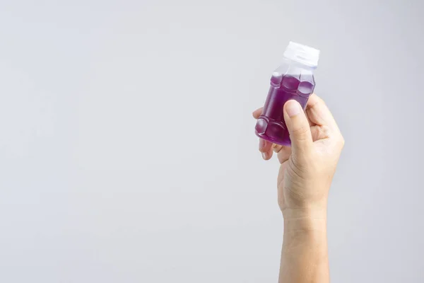 Handen håller en plastflaska av lila växtbaserade dryck från smör — Stockfoto