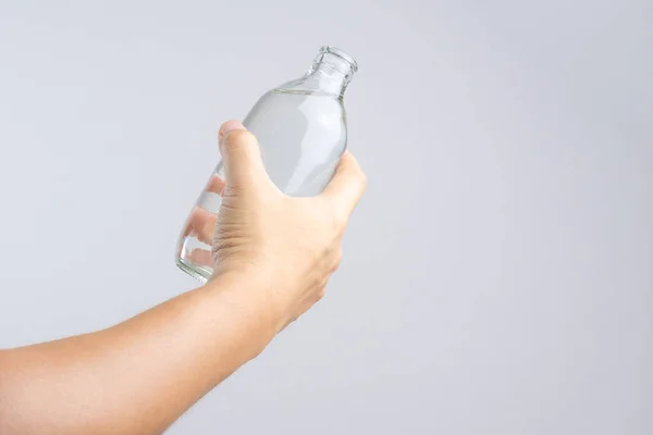 Hand holding glass water bottle — Stock Photo, Image