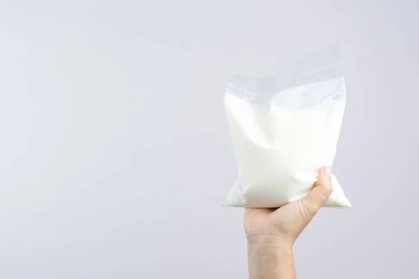 Tenendo in mano un sacchetto di yogurt naturale — Foto Stock