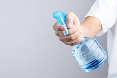 El tutma mavi plastik sprey şişe içeren saf su