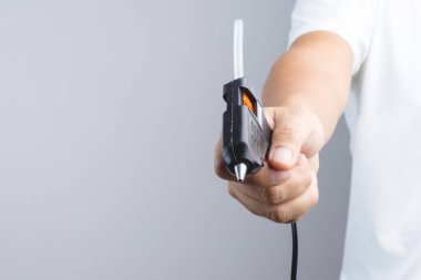 Elektrik sıcak tutkal tabancası tutan el