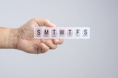 Plastik haftalık hap ya da Braille, ilaç kutusu tutan el t