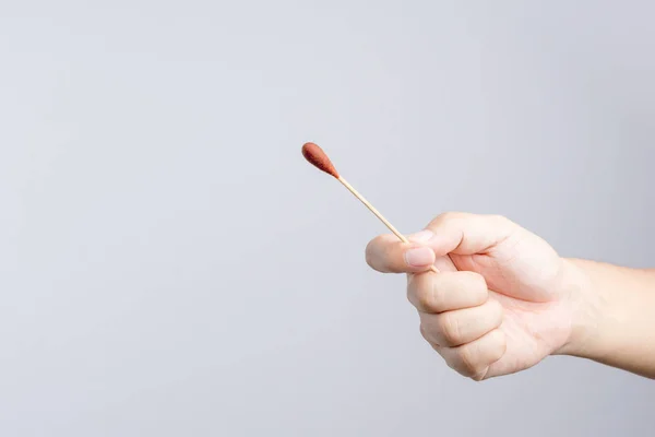 Povidone iyot çubukla yapılmış tahta sopa ve cotto tutan el