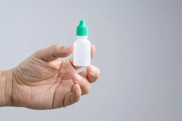 Mão segurando olho ou orelha gota garrafa — Fotografia de Stock