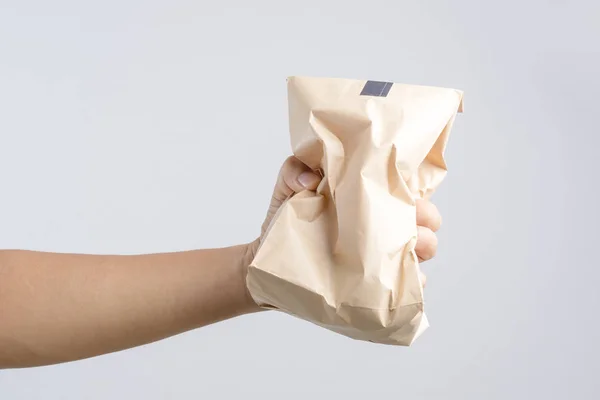 Рука держит крошку коричневый бумажный пакет — стоковое фото