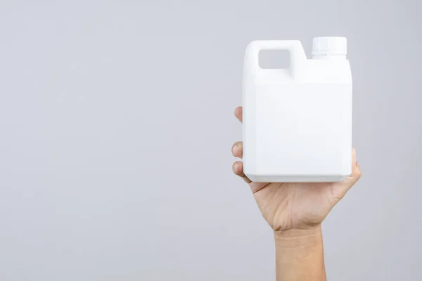 Hand som håller 1000 cc, en liters plastflaska eller 0,26 gallon capa — Stockfoto