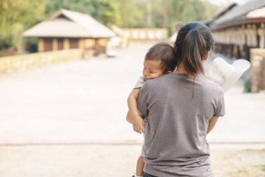 Annesi tarafından tutulan uyuyan Asya bebek