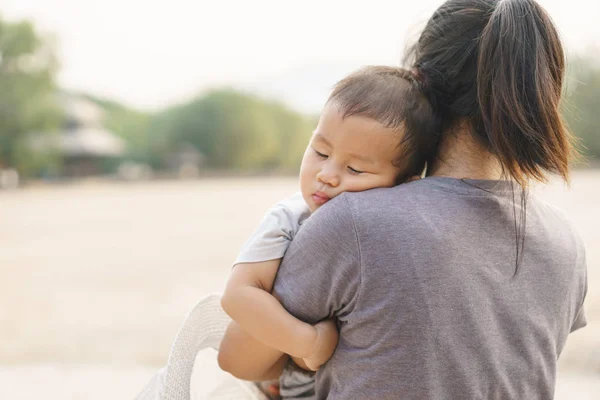 Sleeping Asian baby being held by his mother — Stock Photo, Image