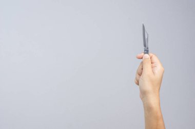 Keskin kat metal çakı beyaz arka plan üzerinde tutan el