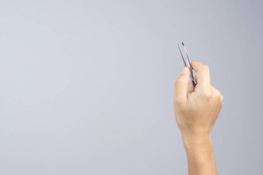 Bazı küçük bir şey almak veya beyaz arka plan üzerinde bir kaş veya saç koparma için el tutma metalik cımbız