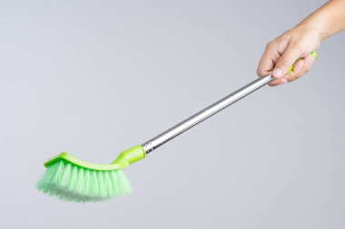 Kat temiz plastik fırça kısa sopa saplı beyaz arka plan üzerinde tutan el