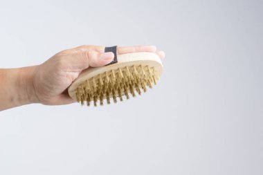 Temizleme ve parlatma zor veya metal ekipman beyaz arka plan üzerinde palm boyutu ahşap saplı yuvarlak pirinç fırça tutan el