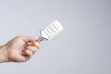 Meyve ve sebze beyaz arka plan üzerinde peeling için rende tutan el