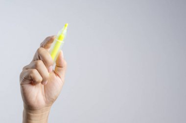 Beyaz arka plan üzerinde bir renk kelime marker yazmak için sarı fosforlu kalem tutan el