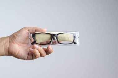 Temiz toz bezle plastik durum kutusu ve siyah plastik reçete optik gözlük beyaz arka plan üzerinde tutan el