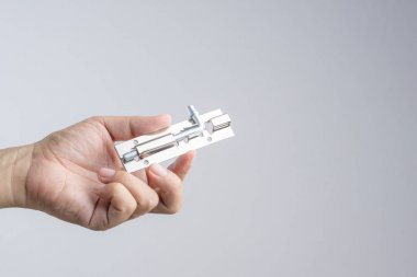 Parlak gümüş renkli paslanmaz çelik kapı cıvata kilit tutan el veya beyaz zemin üzerine mandalı