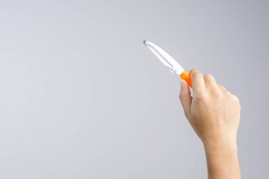 Turuncu kulplu plastik Meyve soyucu beyaz arka plan üzerinde tutan el