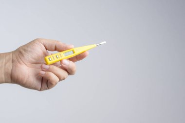 Tornavida dijital lcd devre veya gerilim tester beyaz arka plan üzerinde tutan el