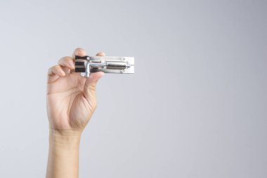 Parlak gümüş renkli paslanmaz çelik kapı cıvata kilit tutan el veya beyaz zemin üzerine mandalı