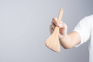 Ahşap kürek, spatula veya flipper tava için beyaz arka plan üzerinde tutan el