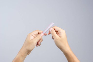 Manicuring ve pedikür, kozmetik bir araç beyaz zemin üzerine çivi dosyası tutan el