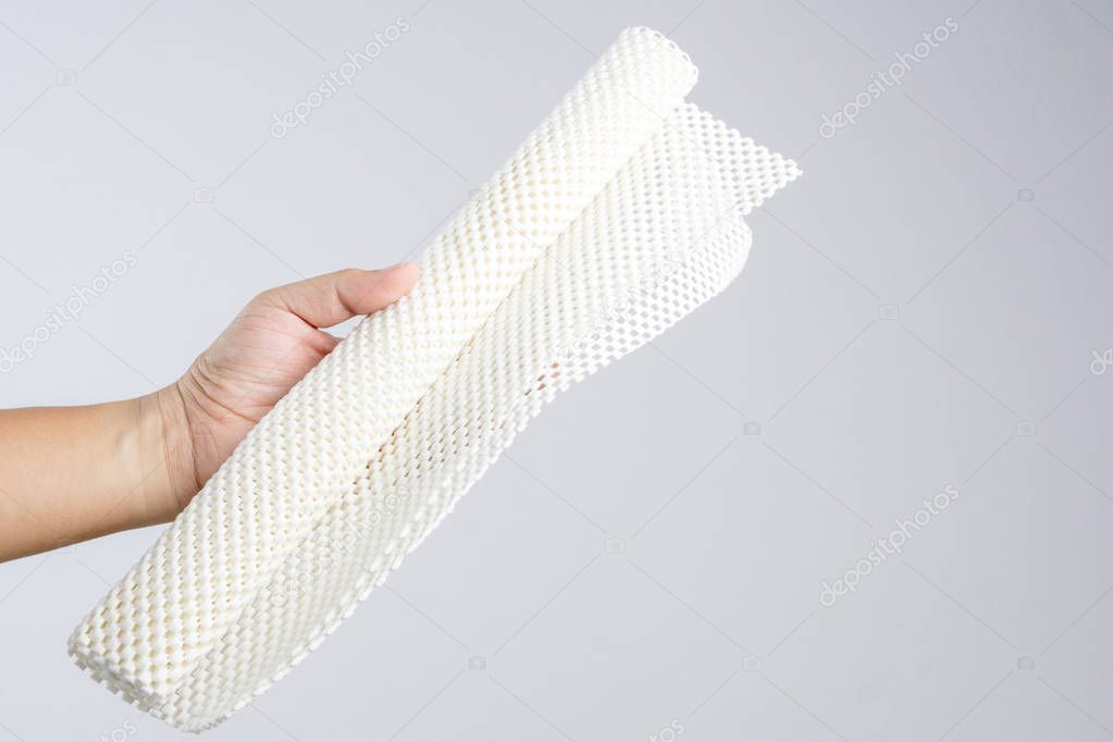 Hand holding white anti slip rubber mat for bathroom or wet floor on white background