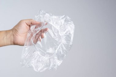Tek kullanımlık şeffaf plastik duş başlığı beyaz arka plan üzerinde tutan el