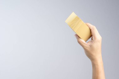 Kahverengi ambalaj bandı rulo beyaz arka planda tutan el