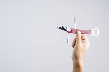 Beyaz arka plan üzerinde çok fonksiyonlar için kısa bıçak ile cep evrensel şişe açacağı tutan el