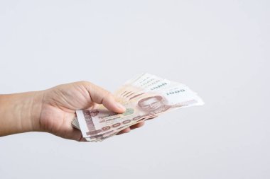 Beyaz arka plan üzerinde Tayland 1000 baht veya para biriminin Tay banknotlar tutan el