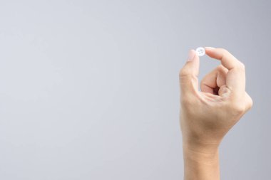 Beyaz arka plan üzerinde beyaz giyim düğmesini tutarak el