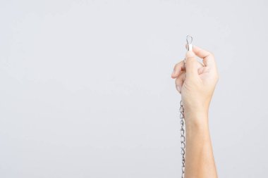 Beyaz arka plan üzerinde metalden yapılmış köpek boğma zincir eğitim tasması tutan el