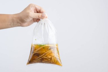 El tutma kızarmış balık haşlanmış maw ile kan kırmızı Gravy çorbası, lastik bant, beyaz arka plan üzerinde bir Tay Çin yemeği tarafından sarılmış plastik torba içinde biber
