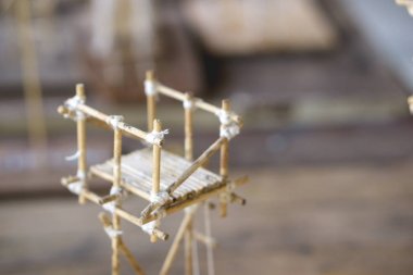 Tahta çubuk, tutkal ve iplikten yapılmış küçük bir yapı.