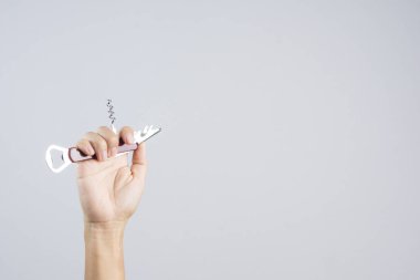 Beyaz arka plan üzerinde çok fonksiyonlar için kısa bıçak ile cep evrensel şişe açacağı tutan el