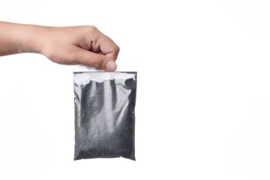 Elinde plastik kömür tozu torbası var.