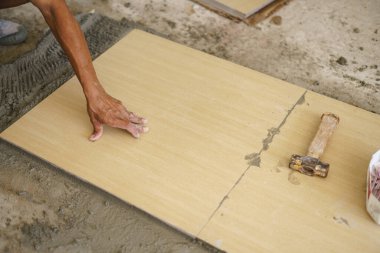 Döşeme döşeyen Asyalı işçi