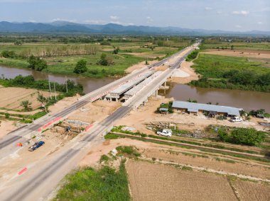 Su kanalı üzerinde köprü inşa eden Asyalı işçiler