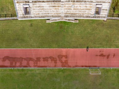 İnsanlar spor yapmak için stadyuma koşuyorlar.