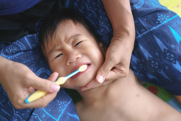 Asiática madre ayudando a su niño cepillarse los dientes para el cuidado dental — Foto de Stock