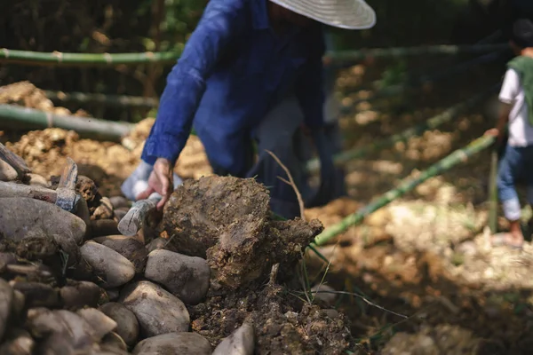 Азиатский рабочий строит дамбу — стоковое фото
