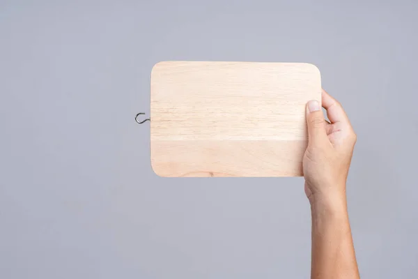 Mão segurando placa de corte de madeira para cozinha — Fotografia de Stock