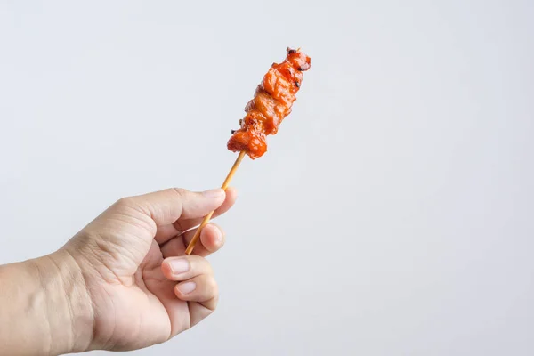 Hand holding grilled chicken meat, an Asian food skewer — Stock Photo, Image