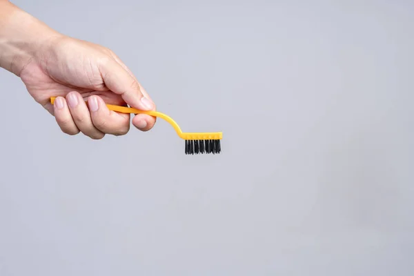 Hand holding small plastic brush with handle — Stock Photo, Image