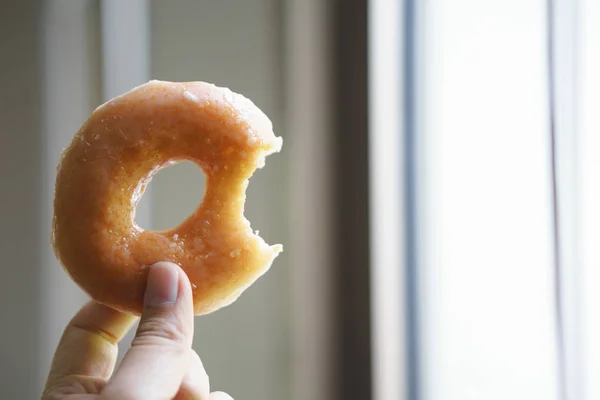 Tangan memegang donat cincin gula Stok Lukisan  